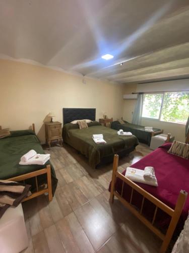 a bedroom with two beds and a living room with a couch at B&B La Casa del Padre Leclef in Valle Hermoso