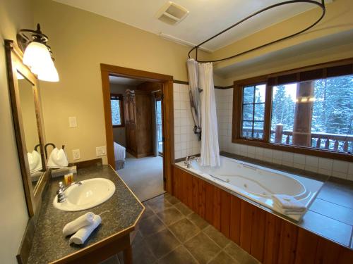 a bathroom with a tub and a sink and a mirror at Winston Lodge in Golden