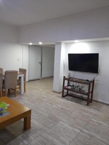 a living room with a flat screen tv on a wall at Maryhouse in Lomas de Zamora