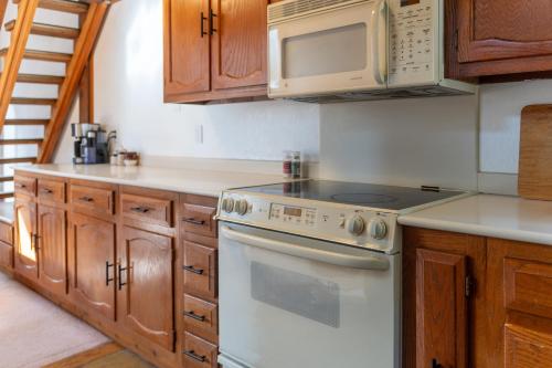 a kitchen with a stove and a microwave at Lofty Retreat, Condo in Northstar in Truckee