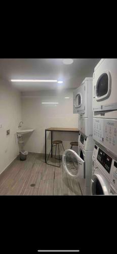 a laundry room with a washing machine and a table at Urban Manizales 703 in Manizales
