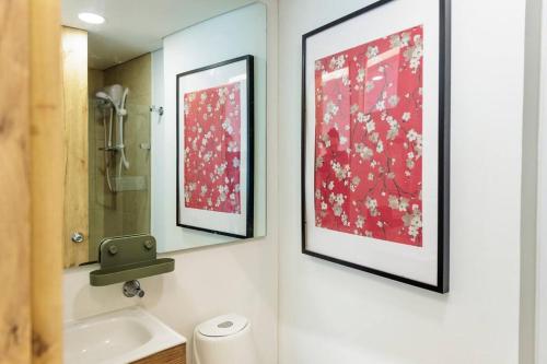uma casa de banho com duas fotografias na parede e um lavatório em * Candelaria with a View * Modern - Central em Bogotá