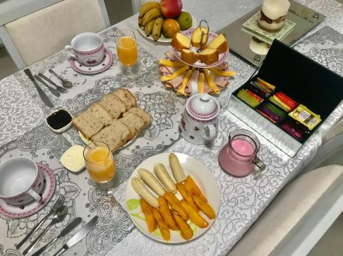 una mesa cubierta con platos de comida y zumo de naranja en Luna, bed&breakfast, en Bombinhas