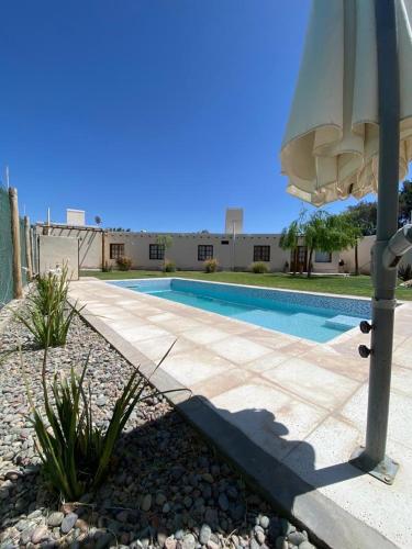 an umbrella sitting next to a swimming pool at EL TOPON cabañas in Albardón