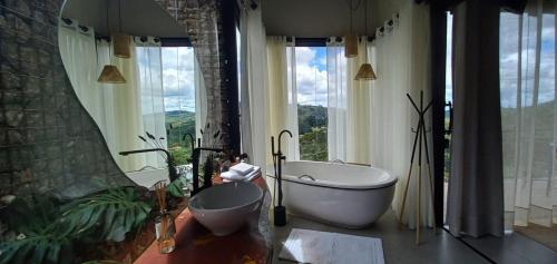 łazienka z wanną i dużym oknem w obiekcie Terra de Kurí w mieście Espírito Santo do Pinhal