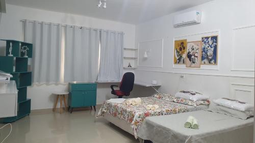 a bedroom with two beds and a desk and a chair at Residencial Mirandinha in Boa Vista