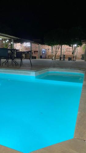 uma piscina à noite com luzes azuis em Chácara Serra Negra em Serra Negra