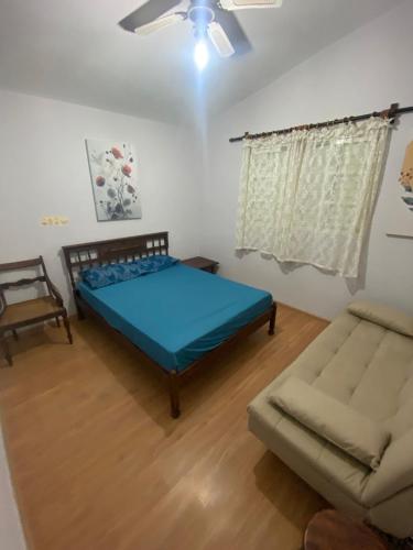 um quarto com uma cama e um sofá em Chácara Serra Negra em Serra Negra