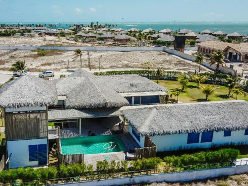 an aerial view of a resort with thatched roofs at Casa Pipa - Pontal de Maceió in Fortim