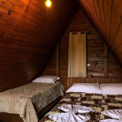 a bedroom with two beds in a wooden cabin at Chalés Altos Da Montanha- Everest in Bom Jardim da Serra