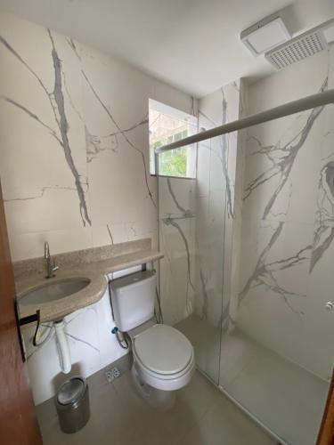 a bathroom with a toilet and a sink at Apartamento completo no centro de Domingos Martins in Domingos Martins