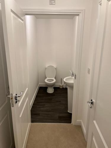 a white bathroom with a toilet and a sink at 28 croft holm 