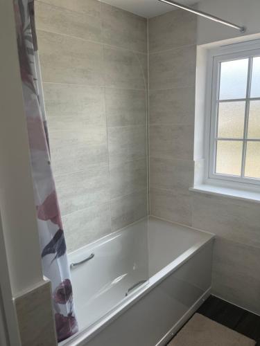 a white bath tub in a bathroom with a window at 28 croft holm 