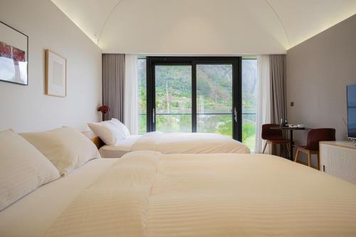 um quarto de hotel com duas camas e uma janela em Healing Stay KOSMOS em Ullŭng