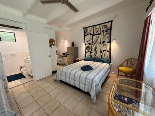 a bedroom with a bed and a kitchen and a bathroom at Magnetic Island Resort Studio in Nelly Bay