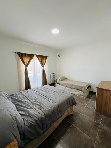a bedroom with two beds and a window at Atuel Alojamiento in San Antonio Oeste