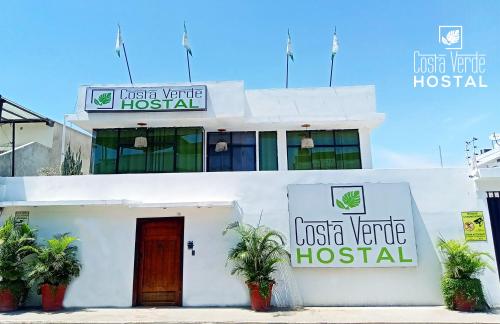 曼塔的住宿－Costa Verde Hostal，一座白色的建筑,上面有医院的标志