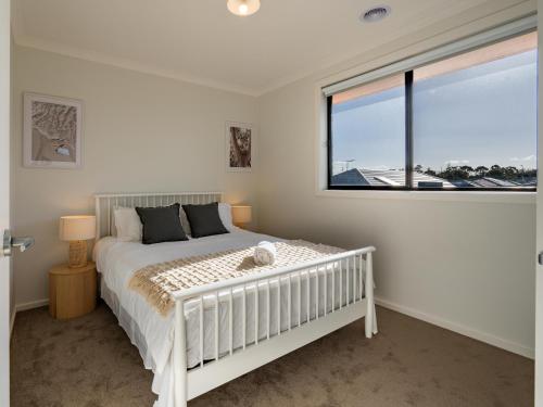 a bedroom with a white bed and a large window at Modern new Homly House at Clyde in Clyde