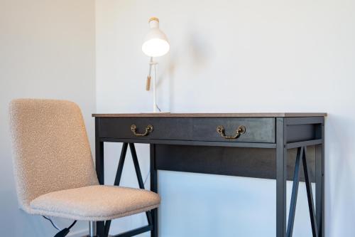a black desk with a chair and a lamp at Modern new Homly House at Clyde in Clyde