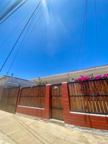 una cerca con puertas de madera y flores en ella en Casa cerca de la playa, en Los Vilos