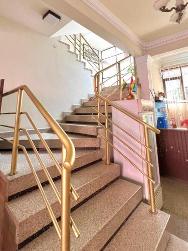 a set of stairs in a house with gold rails at Hostal Escobar in Cochabamba