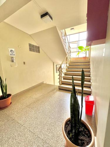 a room with a staircase and a potted plant at Hostal Escobar in Cochabamba