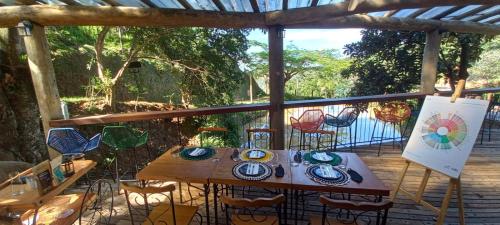 a table and chairs on a deck with a view of the water at Terra de Kurí in Espirito Santo Do Pinhal