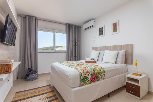 Un dormitorio con una cama grande y una ventana en Vista de Cinema Praia da Armação dos Búzios, en Búzios