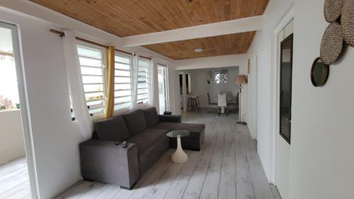 Le Marin的住宿－Maison d'Hanaya，客厅配有沙发和桌子