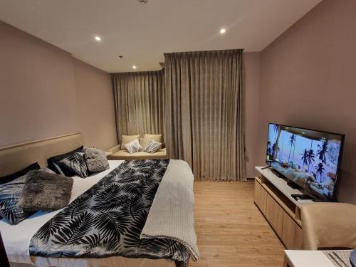 a bedroom with two beds and a flat screen tv at Once Pattaya Seaview Condo in Pattaya Central