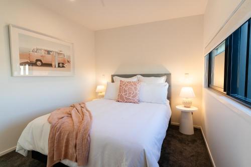 1 dormitorio con cama blanca y ventana en Harbour Haven - A Sunset Oasis! en Tauranga