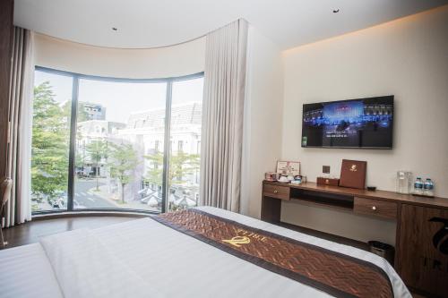 a bedroom with a bed and a large window at Hotel Trí Lê PREMIER in Cao Lãnh