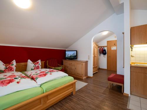 Wellness Ferienwohnung Schweinsteiger mit Hallenbad und Sauna في أوبراودورف: غرفة نوم بسرير كبير وبجدار احمر
