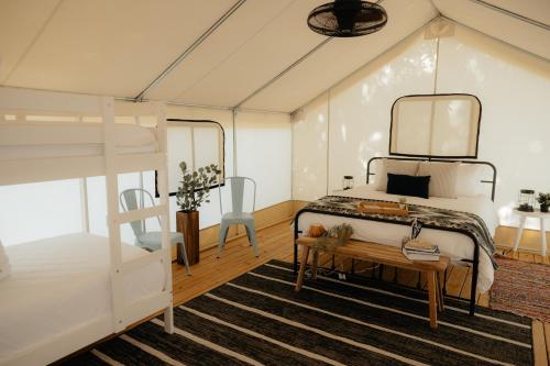 a bedroom with a bunk bed and a table at Luxury Glamping Tents @ Lake Guntersville State Park in Guntersville