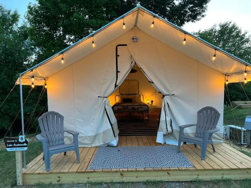 two chairs sitting on a deck in a tent at Luxury Glamping Tents @ Lake Guntersville State Park in Guntersville