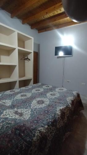 Un dormitorio con una cama y una lámpara. en Departamento en Puerto Madryn