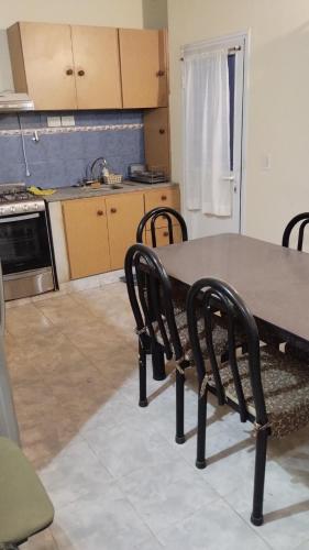 eine Küche mit einem Tisch und Stühlen im Zimmer in der Unterkunft Departamento in Puerto Madryn