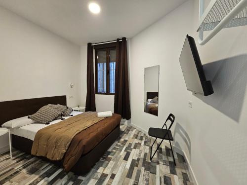 a bedroom with a bed and a flat screen tv at HOSTAL ANDREA GRANVIA in Madrid