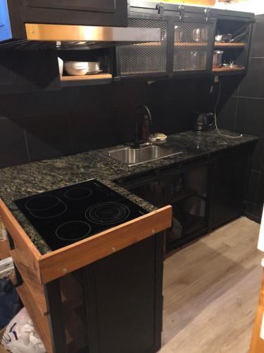 a kitchen with a stove and a sink at Molle Alojamiento Serrano in Villa Icho Cruz