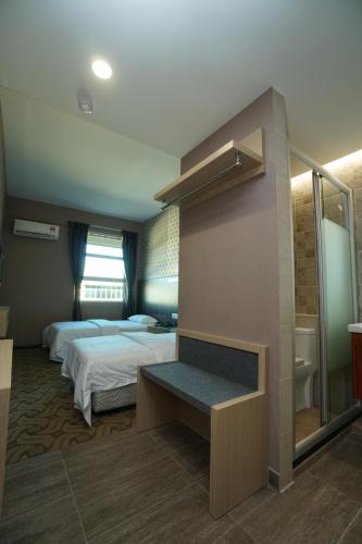 a hotel room with two beds and a bathroom at Regent Hotel in Keningau