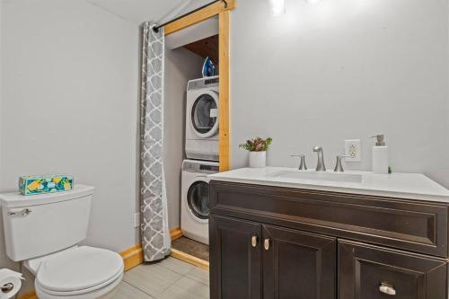 a bathroom with a sink and a washing machine at Cozy Home W/ King Bed & Lake access in Canandaigua