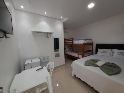 a white room with two beds and a television at HOTEL CENTRAL MARGARITA in Boa Vista