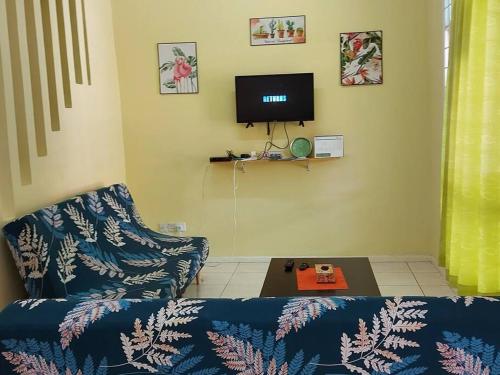 a living room with a couch and a tv at Samma HomeStay Double Storey Terrace House in Kota Kinabalu