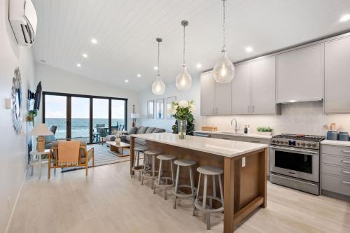 a kitchen with a large island with bar stools at Beachfront Luxury Suite #19 at THE BEACH HOUSE in Campbell River