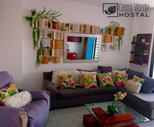 a living room with a couch and a mirror at Costa Verde Hostal in Manta