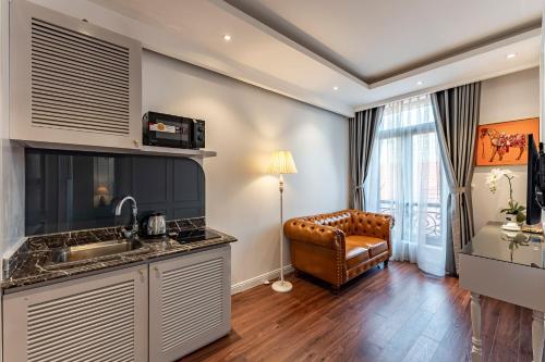 a kitchen with a sink and a couch in a room at Golden Star Apartment & Hotel in Ho Chi Minh City