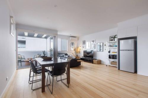 a kitchen and living room with a table and chairs at 'Laidback Lygon' A Two-storey Inner-city Oasis in Melbourne
