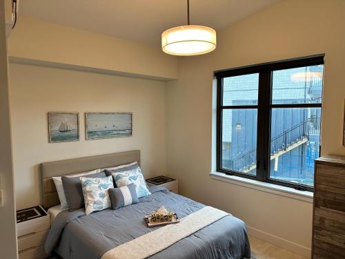 um quarto com uma cama e uma grande janela em Saratoga Serenity at THE BEACH HOUSE em Campbell River