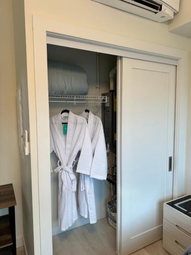 a closet with white clothes hanging in it at Beachfront Villa #14 at The Beach House in Campbell River