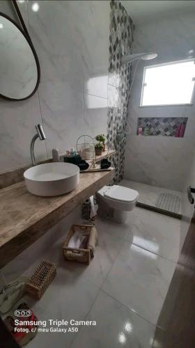 a white bathroom with a sink and a toilet at Casa Nova Araruama in Araruama